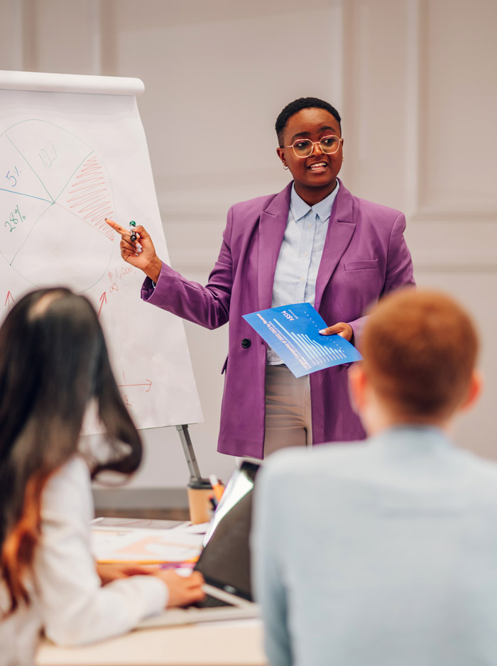 woman presenting at a meeting with pie chart and report focused on data analysis and teamwork six key points